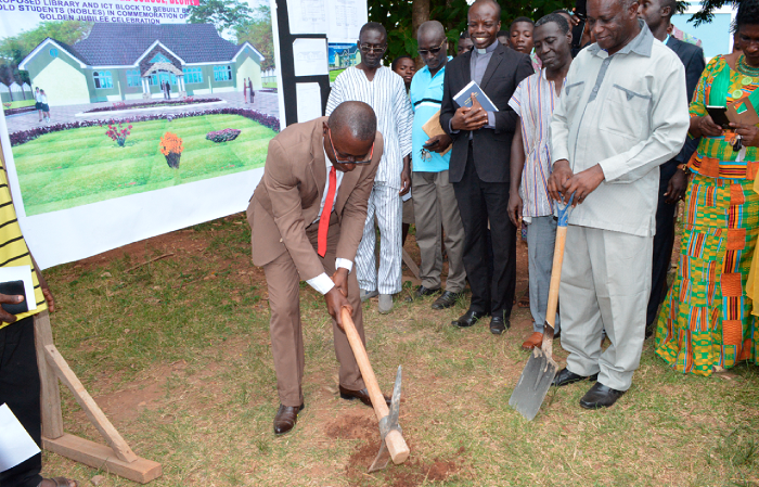 Mr Peter Anarfi-Mensah cutting  the sod for the commencement of work on the library, while Mr Raymond Agyeman (with shovel), Headmaster of the school, also an old student of the school and other old students look on.
